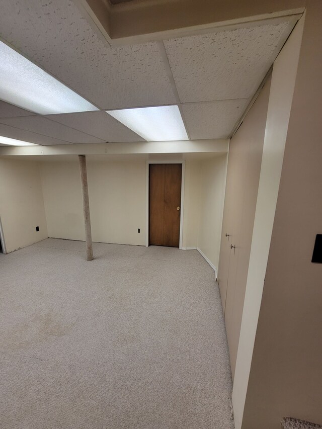 finished basement featuring light carpet and a drop ceiling