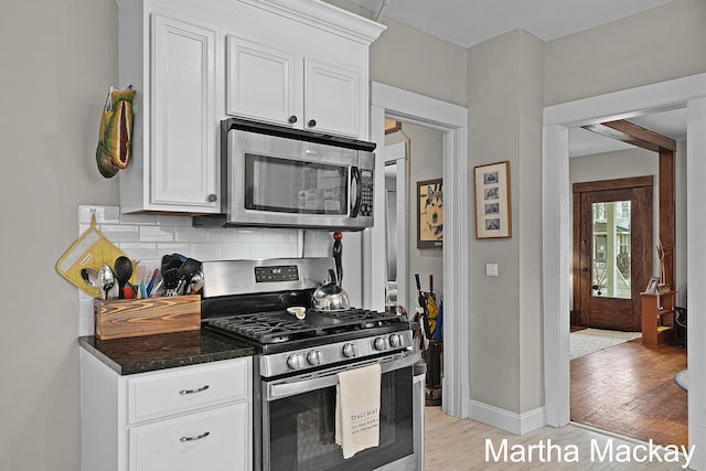 625 Leonard St NE, Grand Rapids, MI 49503 - kitchen featuring stainless steel appliances, decorative backsplash, light wood-type flooring, and white cabinetry