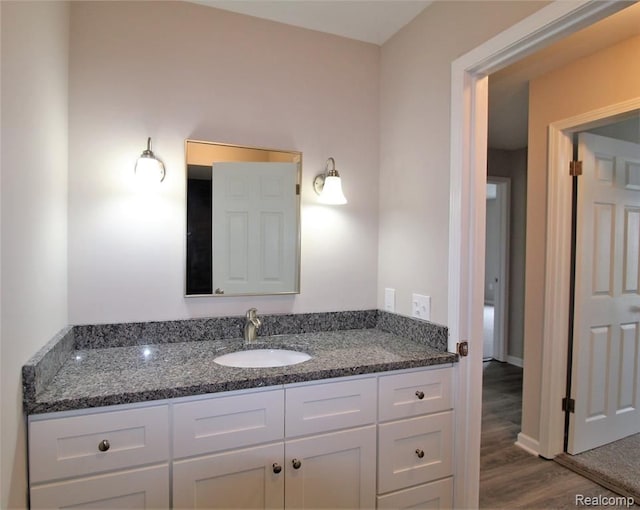 bathroom featuring wood finished floors, vanity, and baseboards