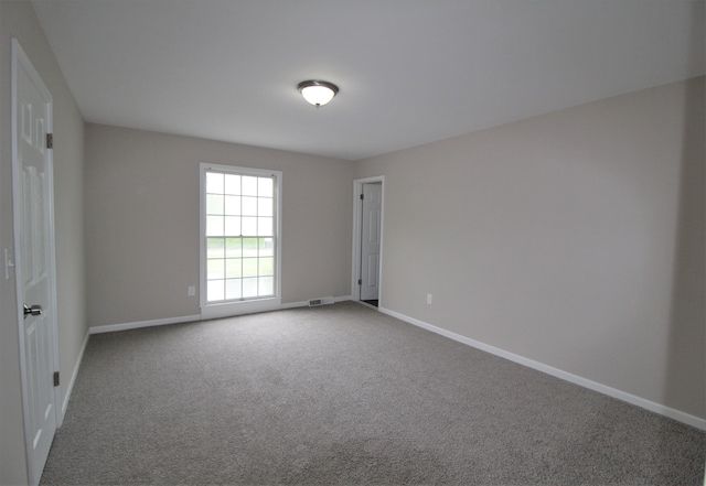 carpeted spare room with baseboards