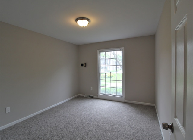 carpeted empty room featuring healthy amount of natural light and baseboards