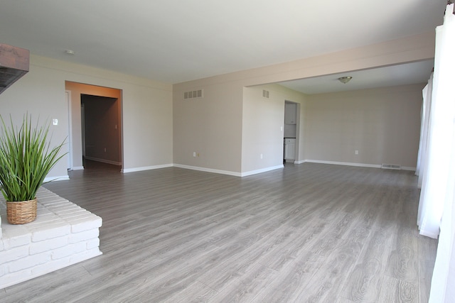 unfurnished living room with wood finished floors and baseboards