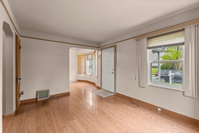 18310 Harman St, Melvindale, MI 48122 - unfurnished room with arched walkways, light wood-type flooring, plenty of natural light, and baseboards