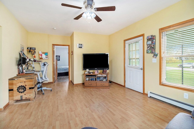 185 S Madison Ave, Custer, MI 49405 - exercise room featuring a baseboard heating unit, light wood-style flooring, a ceiling fan, and baseboards