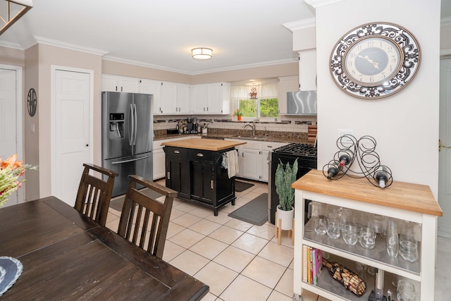 kitchen featuring stainless steel fridge with ice dispenser, wood counters, white cabinetry, tasteful backsplash, and crown molding