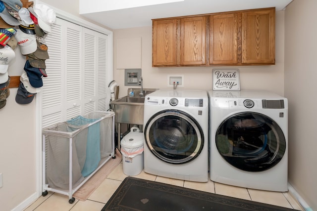 laundry room featuring washer and dryer, cabinet space, light tile patterned floors, and baseboards