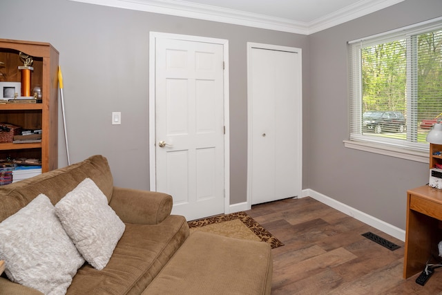 living room featuring wood finished floors, crown molding, and baseboards