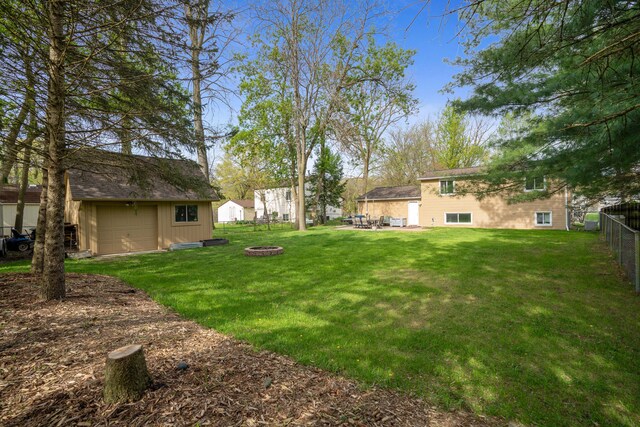 view of yard featuring an outdoor fire pit, a garage, and an outdoor structure