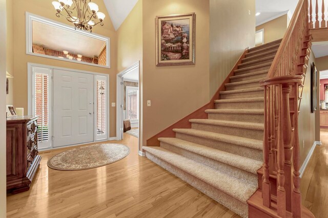28022 Ashland Ave, Harrison Township, MI 48045 - foyer featuring light wood-type flooring, stairs, a chandelier, and high vaulted ceiling