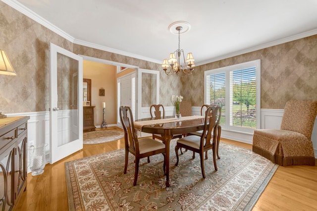 28022 Ashland Ave, Harrison Township, MI 48045 - dining room with a chandelier, ornamental molding, light wood-style floors, a wainscoted wall, and a decorative wall
