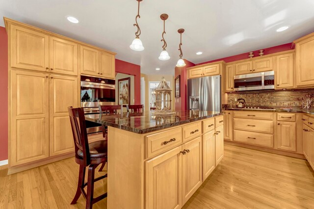 28022 Ashland Ave, Harrison Township, MI 48045 - kitchen with appliances with stainless steel finishes, light brown cabinetry, a kitchen bar, a center island, and light wood-type flooring