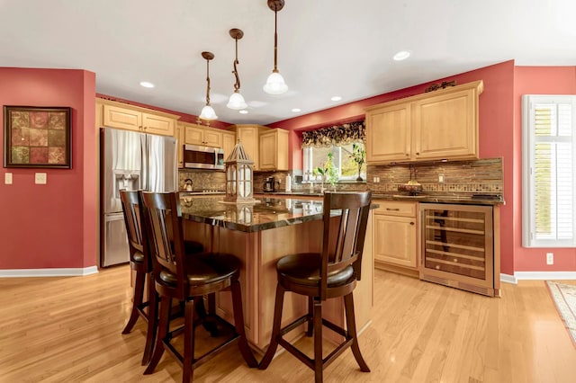 28022 Ashland Ave, Harrison Township, MI 48045 - kitchen featuring stainless steel appliances, beverage cooler, decorative backsplash, light wood-style floors, and a kitchen bar