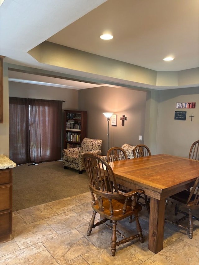 dining space with light colored carpet and light stone finish flooring
