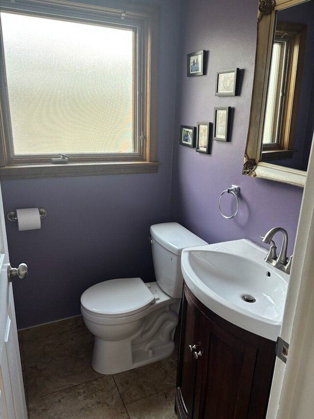 bathroom with toilet, vanity, and tile patterned floors