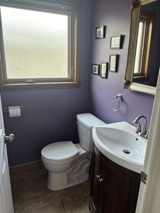 bathroom with toilet, vanity, and tile patterned floors