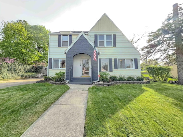 view of front of home with a front yard and brick siding
