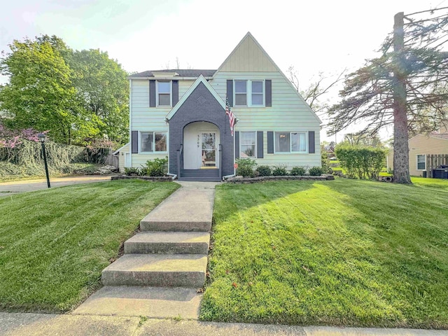 view of front facade with a front yard and brick siding