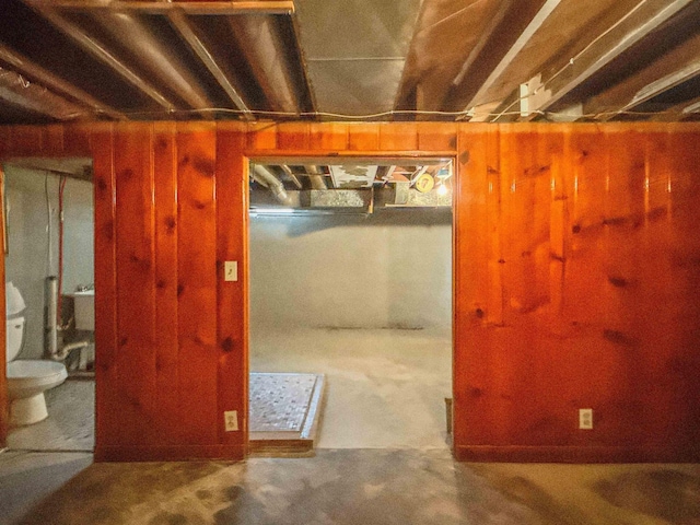 unfinished below grade area featuring wood walls