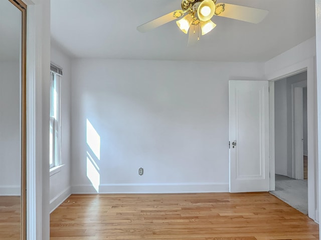 spare room featuring light wood-type flooring, plenty of natural light, and ceiling fan