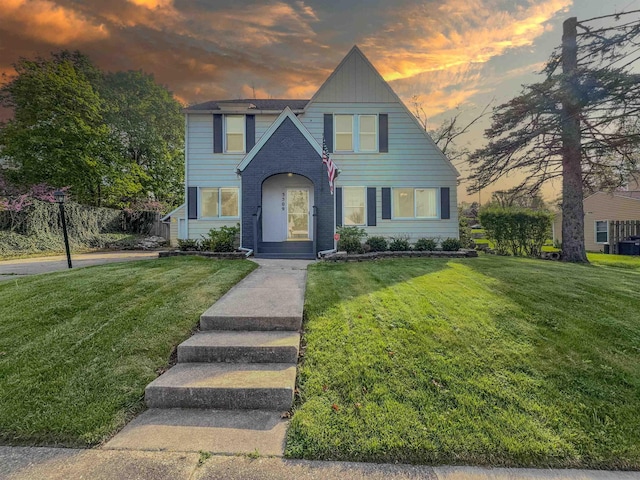 view of front of house with a front lawn and brick siding