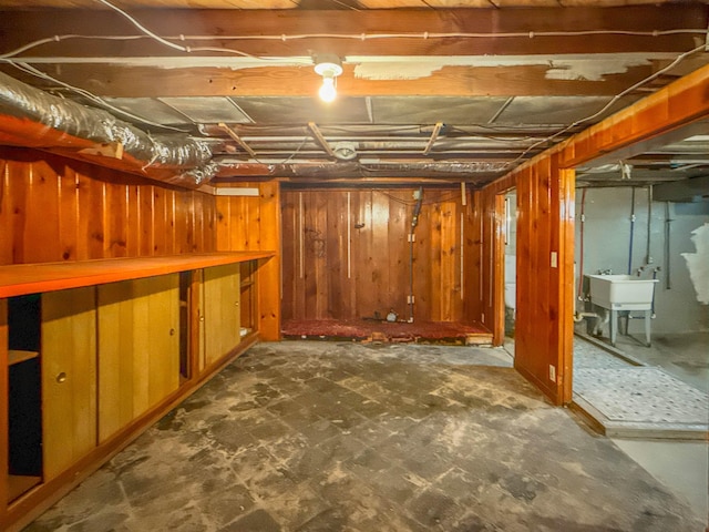 unfinished below grade area featuring a sink and wood walls