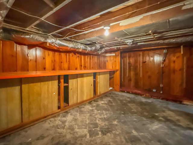 unfinished basement featuring wooden walls
