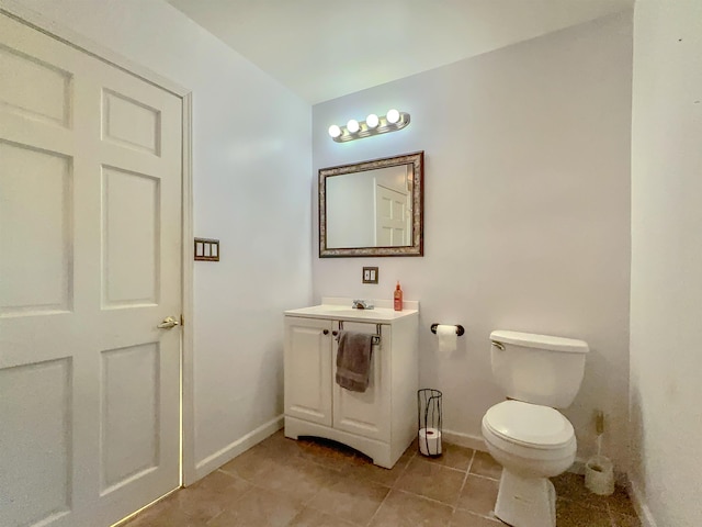 bathroom featuring baseboards, toilet, vanity, and tile patterned floors