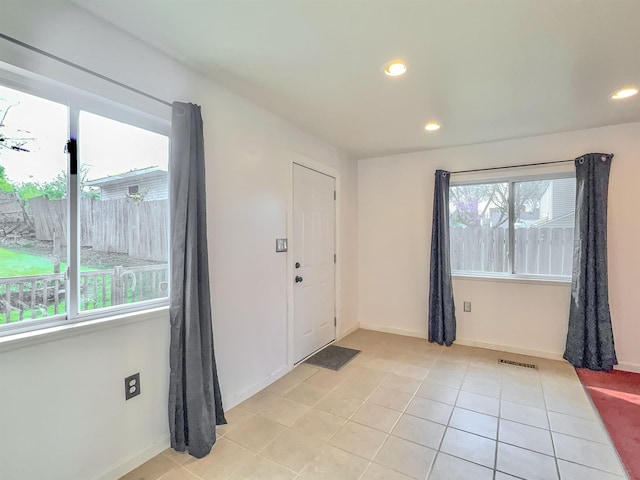 foyer entrance with recessed lighting, light tile patterned floors, and baseboards
