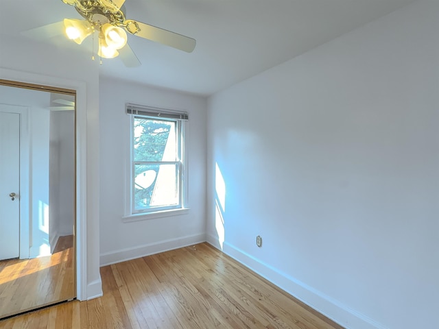 unfurnished bedroom with light wood-style flooring, baseboards, ceiling fan, and a closet