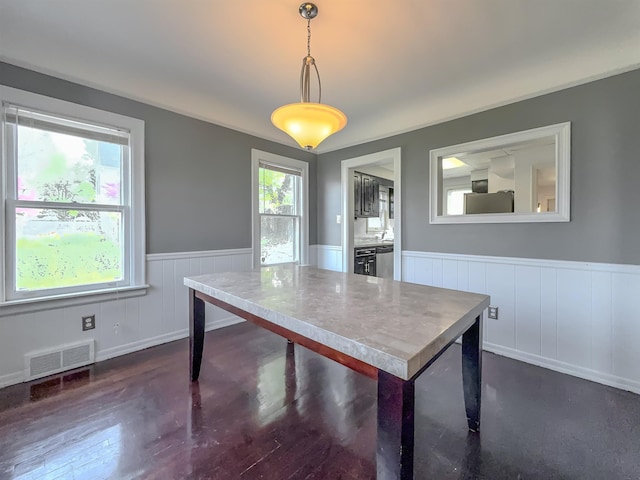 dining space featuring wainscoting, dark wood-type flooring, and beverage cooler
