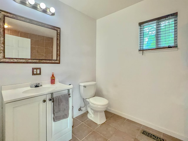 bathroom with baseboards, vanity, tile patterned floors, and toilet