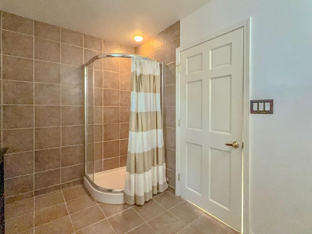 full bath with a shower stall and tile patterned flooring