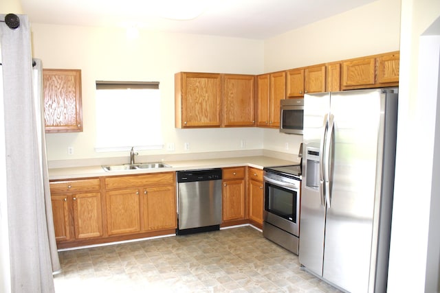9541 Lakeside Dr, Ypsilanti, MI 48197 - kitchen featuring appliances with stainless steel finishes, a sink, light countertops, and brown cabinetry