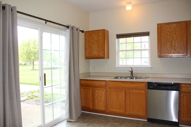 9541 Lakeside Dr, Ypsilanti, MI 48197 - kitchen with stainless steel dishwasher, a sink, light countertops, brown cabinetry, and stone finish floors