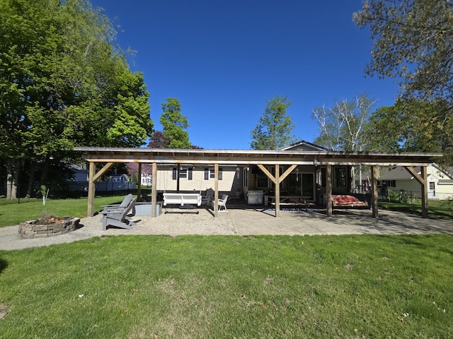 rear view of house with a fire pit and a patio area