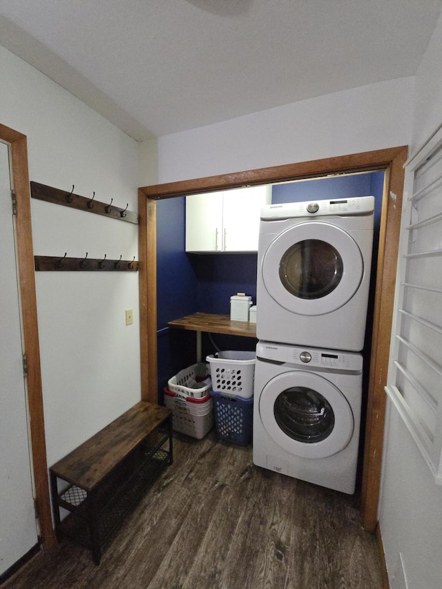 laundry room featuring cabinet space, estacked washer and dryer, and wood finished floors