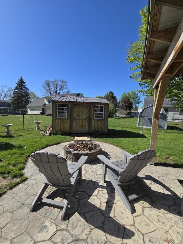 view of patio / terrace with an outdoor fire pit, an outdoor structure, and a shed