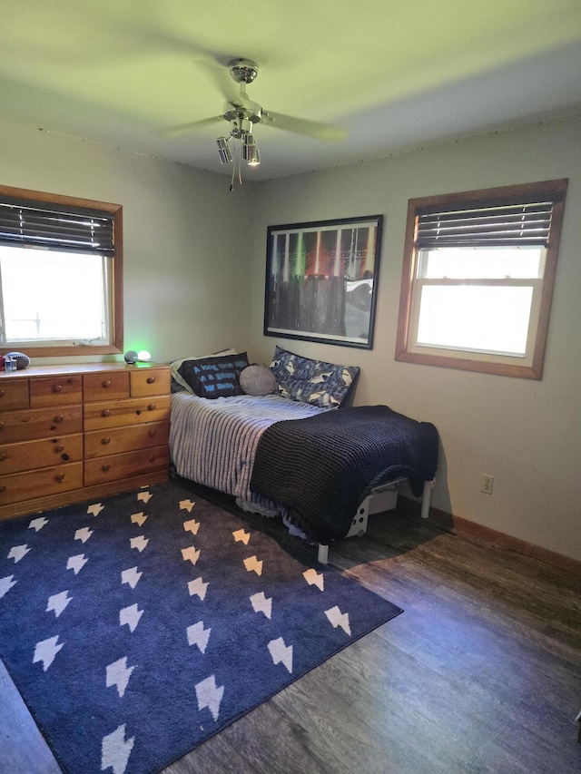 bedroom featuring multiple windows, wood finished floors, and ceiling fan