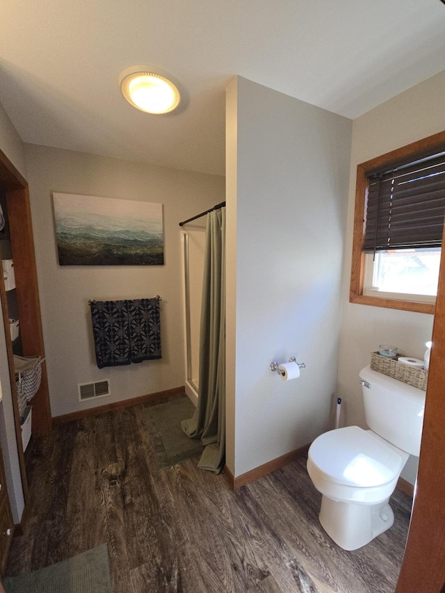 full bathroom featuring wood finished floors, toilet, curtained shower, and baseboards