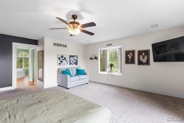 bedroom featuring light colored carpet, multiple windows, baseboards, and ceiling fan