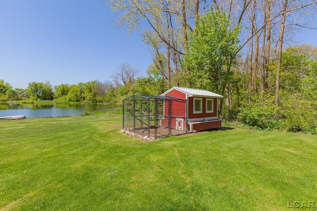 view of poultry coop featuring a water view and a lawn