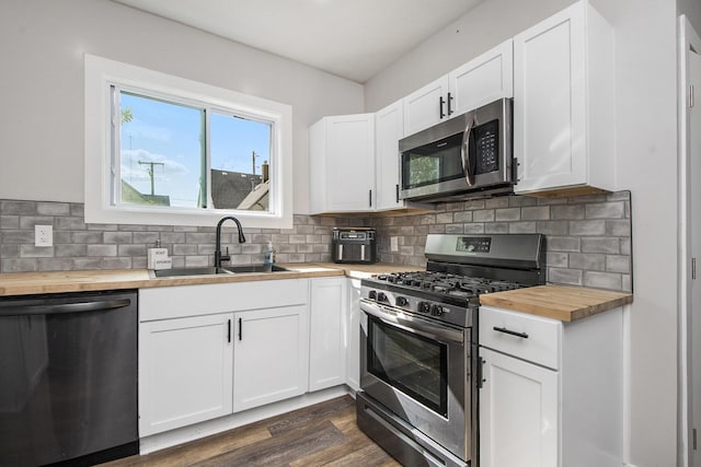 30 Palmer St NW, Grand Rapids, MI 49505 - kitchen with butcher block countertops, stainless steel appliances, a sink, and decorative backsplash