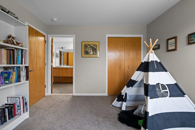 recreation room with carpet floors and baseboards