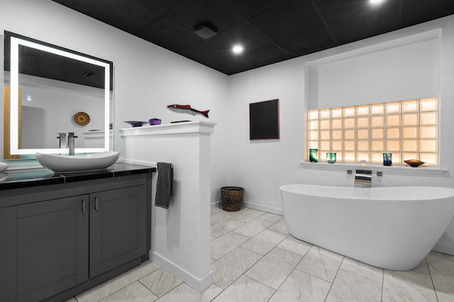 bathroom with marble finish flooring, vanity, baseboards, and recessed lighting