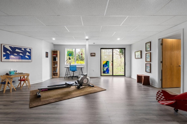 exercise room with wood finished floors, a paneled ceiling, baseboards, and recessed lighting