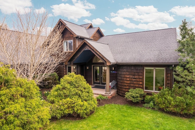 view of front facade featuring a front lawn and roof with shingles