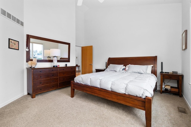 bedroom featuring carpet flooring, a high ceiling, baseboards, and ceiling fan