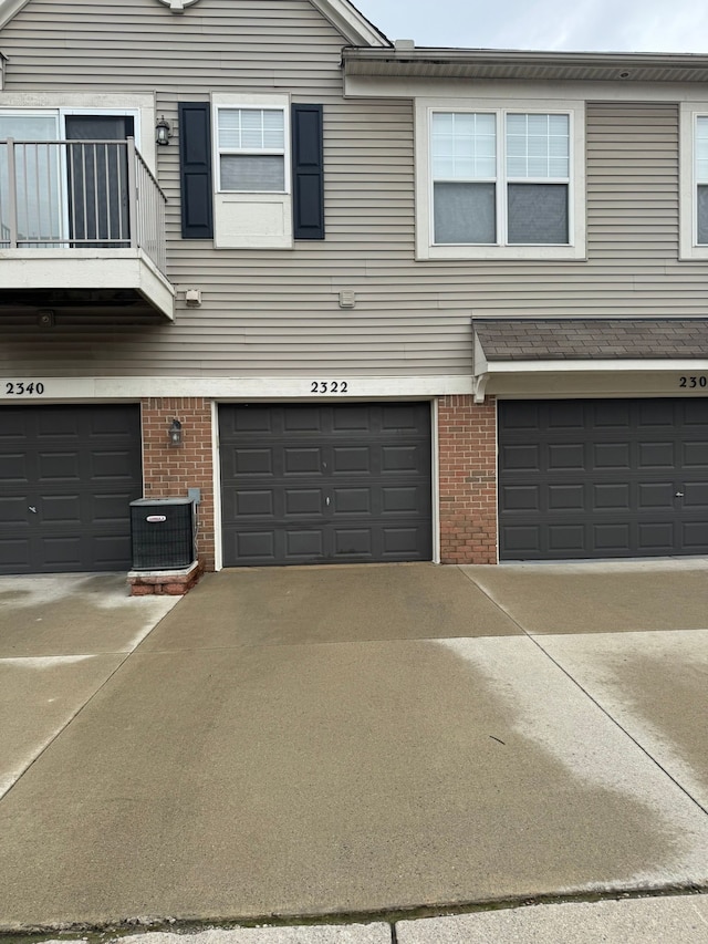 2322 Arcadia Dr, Canton, MI 48188 - view of front of property featuring brick siding, an attached garage, central AC unit, and a balcony