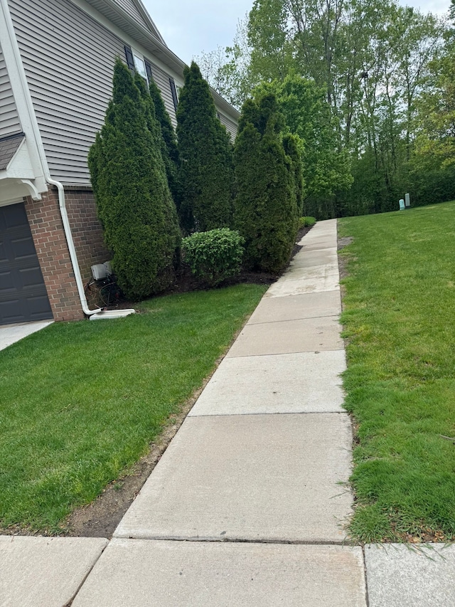 2322 Arcadia Dr, Canton, MI 48188 - view of home's exterior featuring a yard, brick siding, and a garage