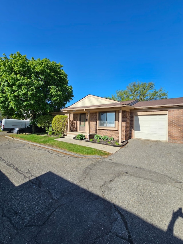 view of front of house featuring brick siding, a garage, and driveway